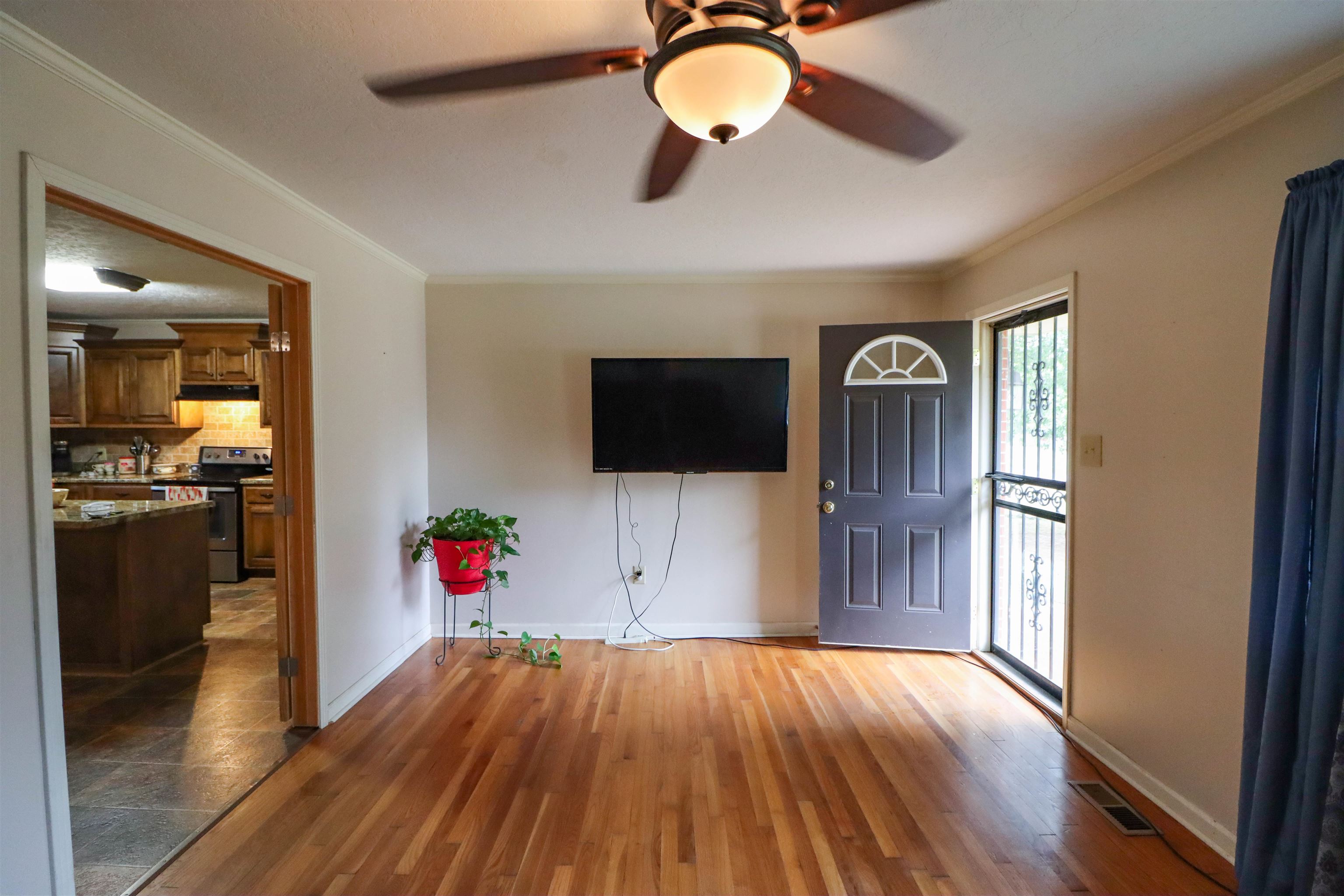 2143 Toulon Road Ripley, TN 38063 - Photo 7 of 39 Living area featuring crown molding, original hardwood flooring, and a ceiling fan