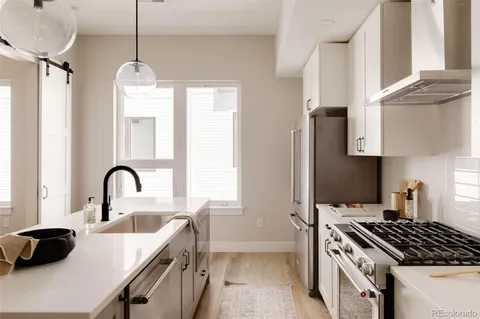 a kitchen with granite countertop a sink a stove and refrigerator