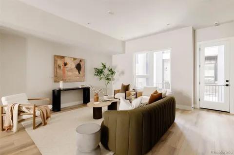 a living room with furniture a large window and a fireplace