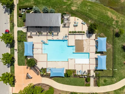 an aerial view of residential houses with outdoor space and parking