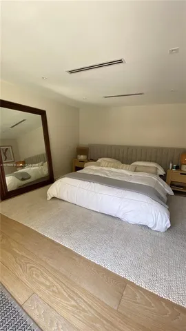 a bedroom with a bed and a mirror