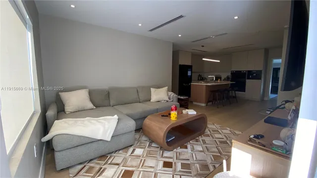 a living room with furniture and kitchen view