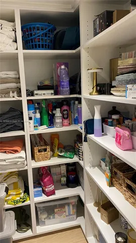 a utility room with stainless steel appliances and a wooden floor