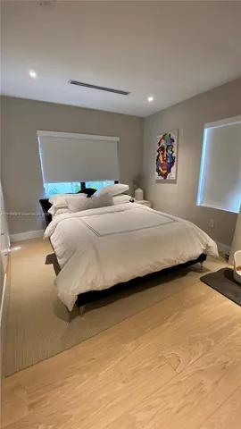 a bedroom with a bed and painting on the wall