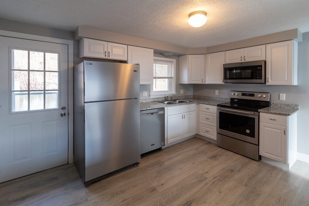 20 Rice Lane, Unit 2 Worcester, MA 01604 - Photo 1 of 17 a kitchen with a refrigerator stove and wooden cabinets