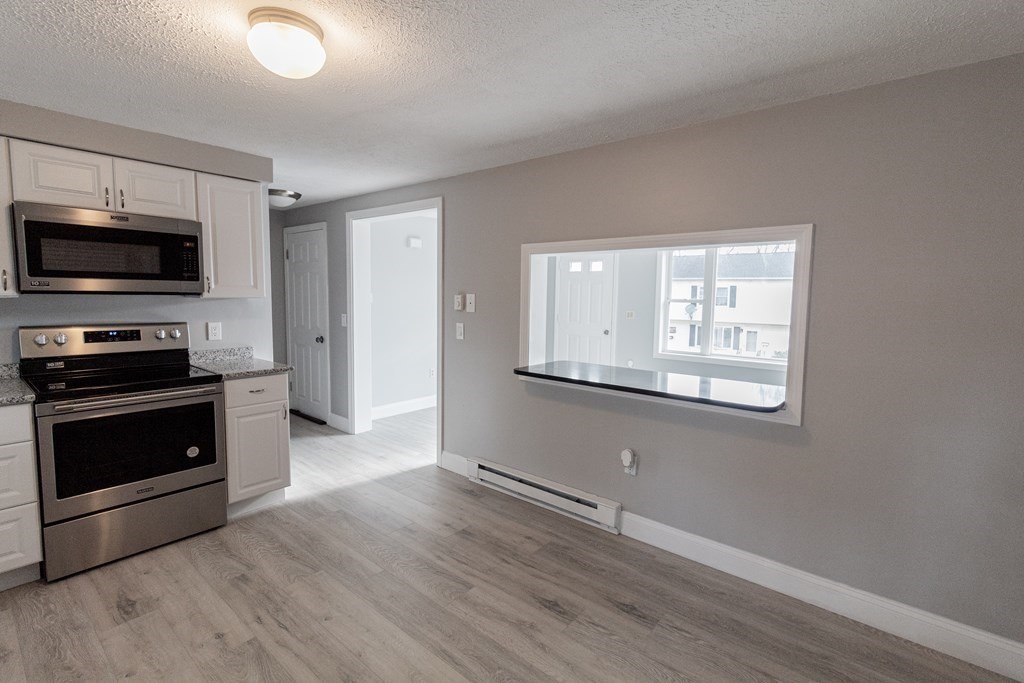 20 Rice Lane, Unit 2 Worcester, MA 01604 - Photo 2 of 17 a kitchen with cabinets wooden floor and stainless steel appliances