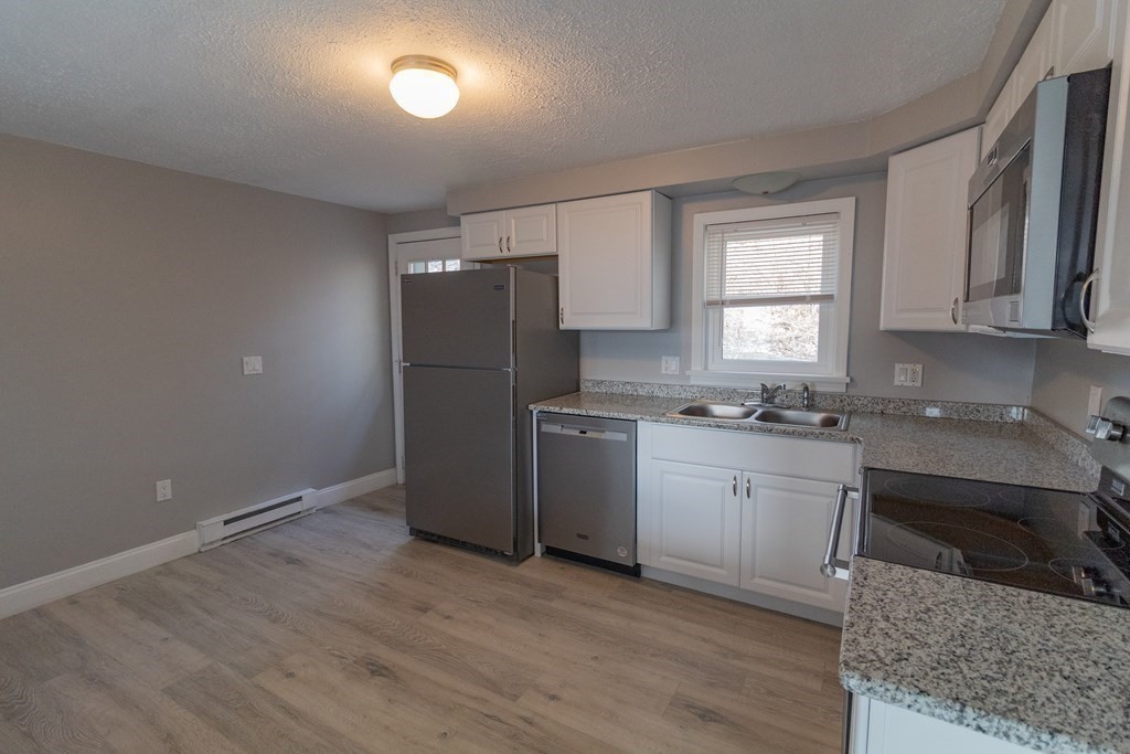 20 Rice Lane, Unit 2 Worcester, MA 01604 - Photo 3 of 17 a kitchen with granite countertop a refrigerator and a sink