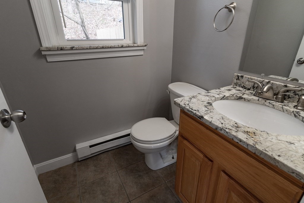 20 Rice Lane, Unit 2 Worcester, MA 01604 - Photo 6 of 17 a bathroom with a granite countertop toilet sink and mirror