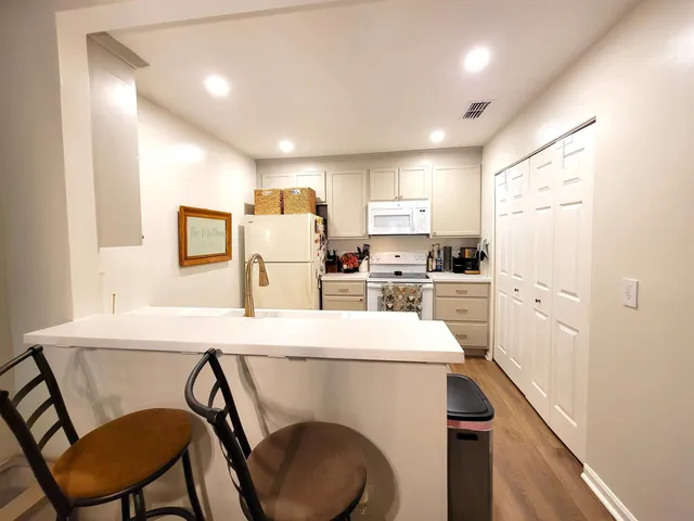 a kitchen with a dining table chairs refrigerator and cabinets