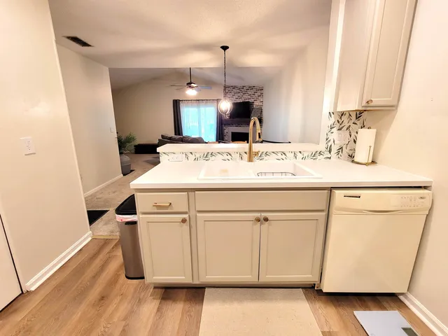 a kitchen with a sink cabinets and wooden floor
