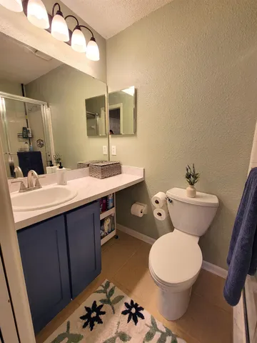 a bathroom with a toilet sink and mirror