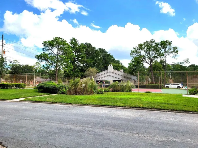 a view of a house with a yard and a fountain