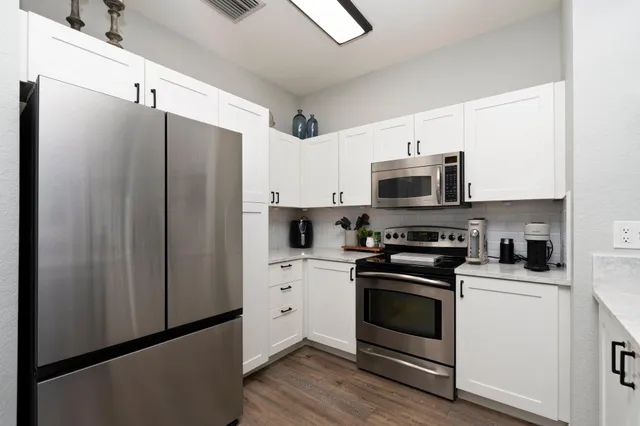 a kitchen with stainless steel appliances a refrigerator stove and microwave