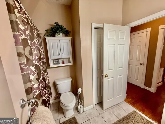 a white toilet sitting next to a shower curtain