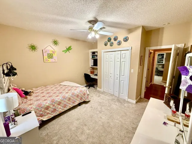 a bedroom with a bed flat screen tv and a chandelier