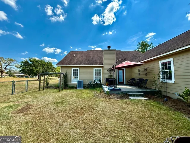 a view of a house with a patio and a yard