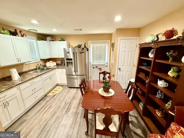 a kitchen with sink refrigerator dining table and chairs