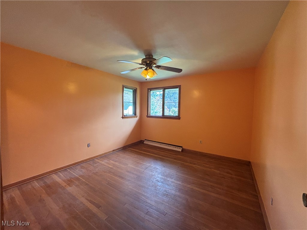 4912 Hillside Road Independence, OH 44131 - Photo 11 of 20 Unfurnished room with dark wood-style floors, a baseboard radiator, and a ceiling fan