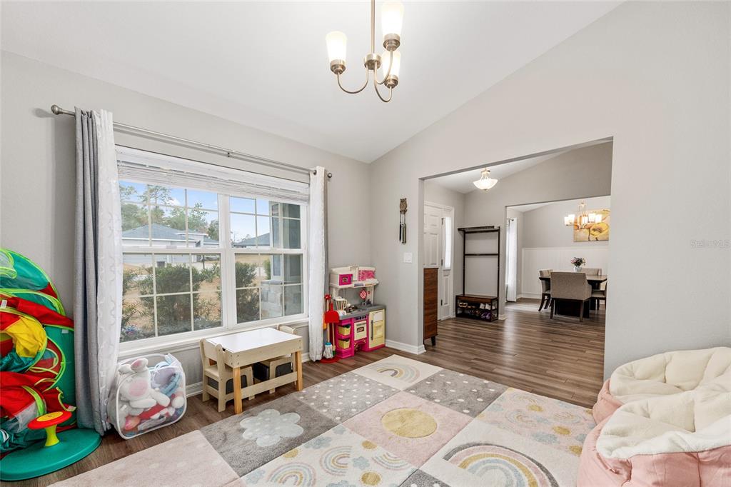 11275 Southwest 54th Circle Ocala, FL 34476 - Photo 18 of 63 a bedroom with furniture and a chandelier