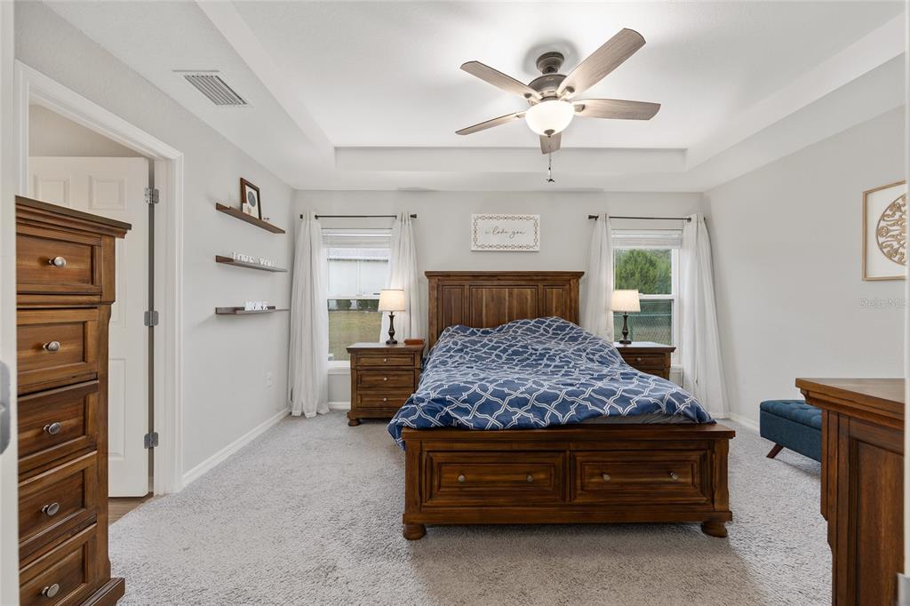 11275 Southwest 54th Circle Ocala, FL 34476 - Photo 34 of 63 a bedroom with a large bed and a chandelier