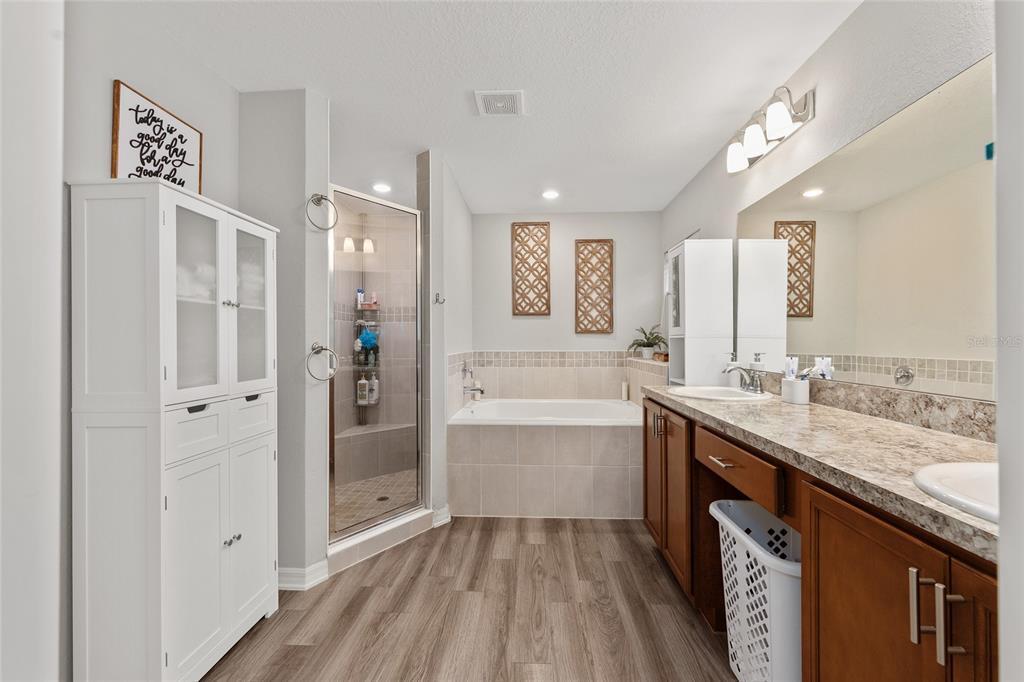 11275 Southwest 54th Circle Ocala, FL 34476 - Photo 39 of 63 a bathroom with a granite countertop double vanity sink a mirror and a bathtub