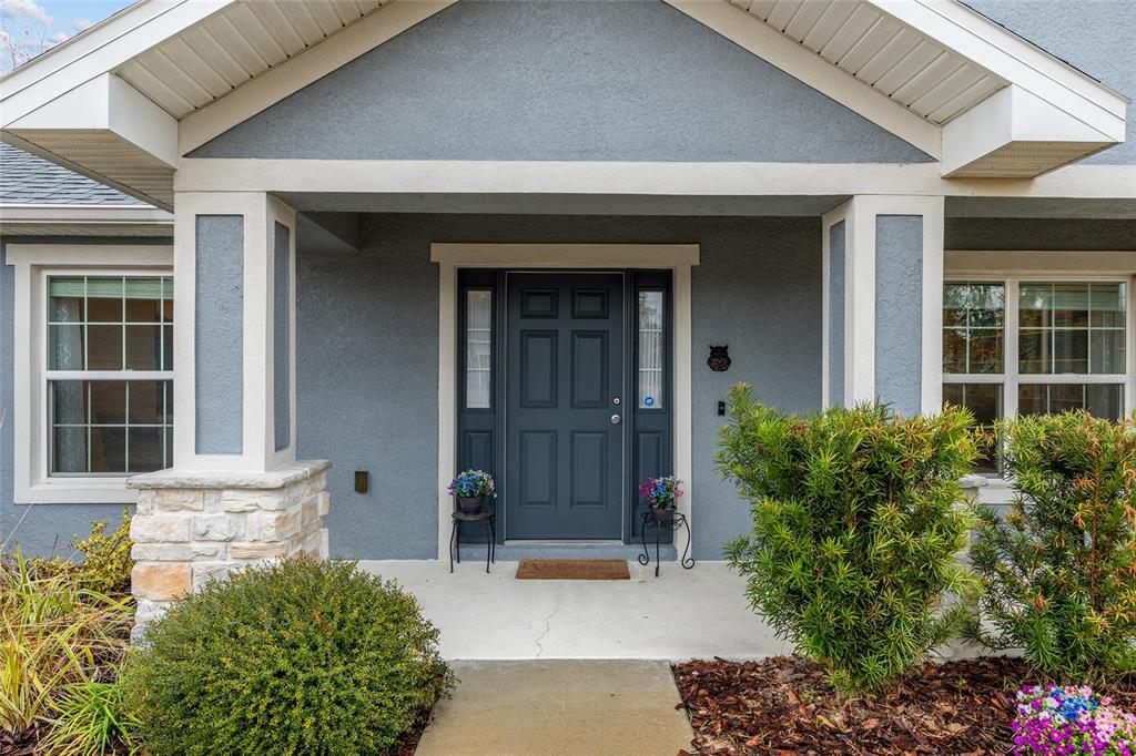 11275 Southwest 54th Circle Ocala, FL 34476 - Photo 9 of 63 front view of a brick house with a large window and potted plants