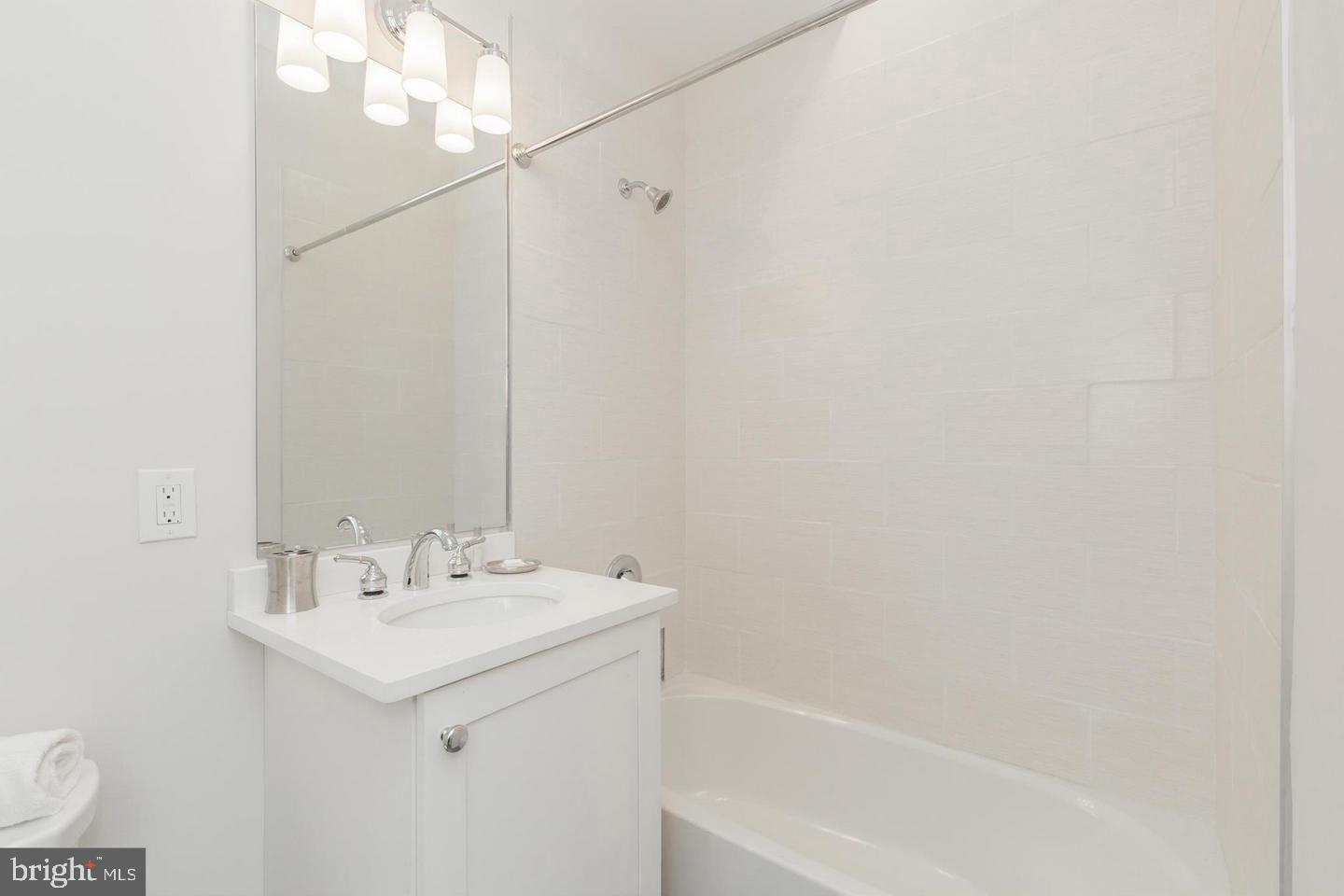 1352 Quincy Street Northwest, Unit 1 Washington, DC 20011 - Photo 13 of 26 a bathroom with a sink a mirror and a bathtub