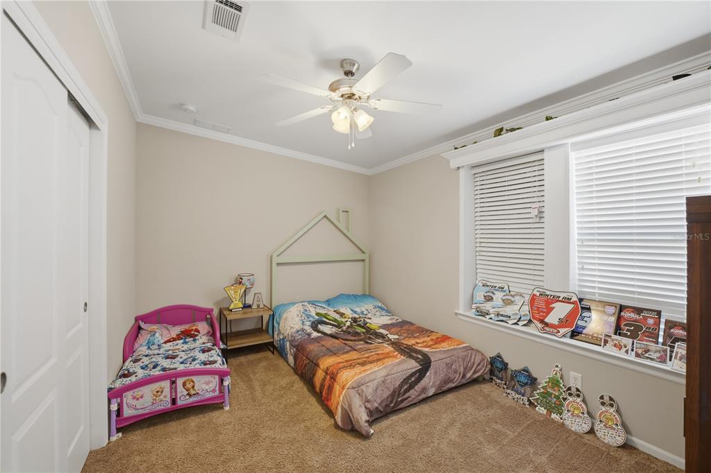 6844 Chad Jason Road St. Cloud, FL 34773 - Photo 21 of 59 a bedroom with two bed and a chandelier