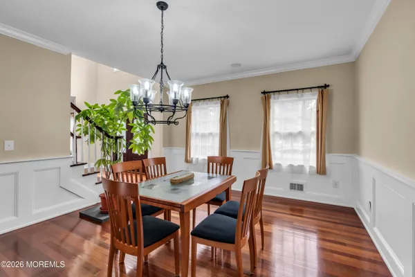 a dining room with furniture potted plants and wooden floor