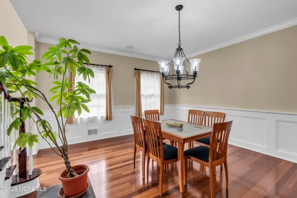 a dining room with furniture potted plants and wooden floor