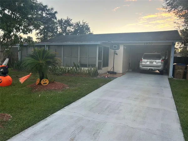 a view of a house with backyard and a tree