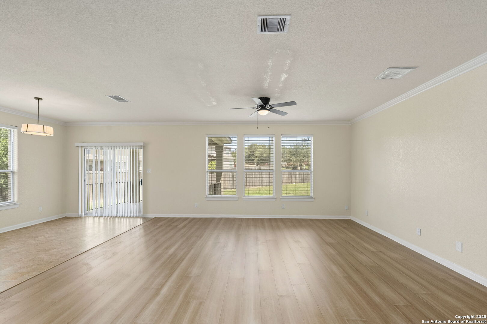 213 Springtree Parkway Cibolo, TX 78108 - Photo 10 of 33 an empty room with wooden floor and windows