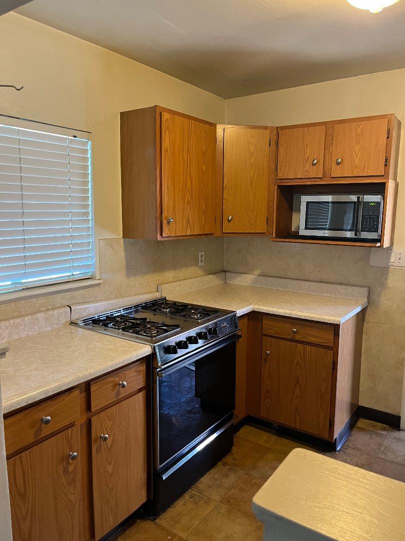 128 Laumer Avenue San Jose, CA 95127 - Photo 17 of 18 a kitchen with stainless steel appliances granite countertop a stove microwave and cabinets
