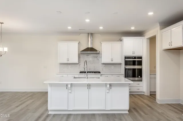 a kitchen that has a sink a refrigerator and a stove top oven