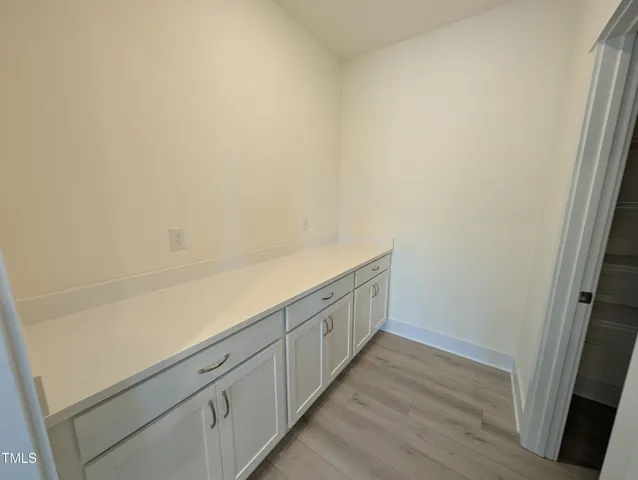 a view of storage and utility room with wooden floor