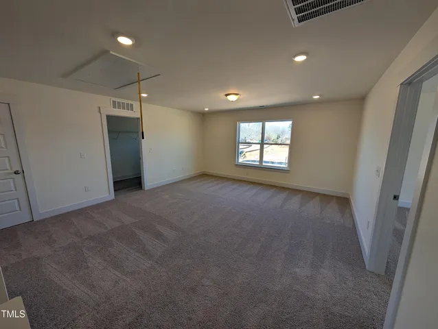 a view of a big room with wooden floor and windows