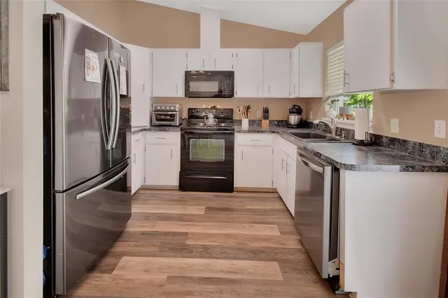 a kitchen with stainless steel appliances granite countertop a refrigerator stove and microwave