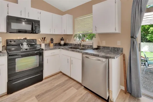 a kitchen with stainless steel appliances granite countertop a stove a sink and a microwave