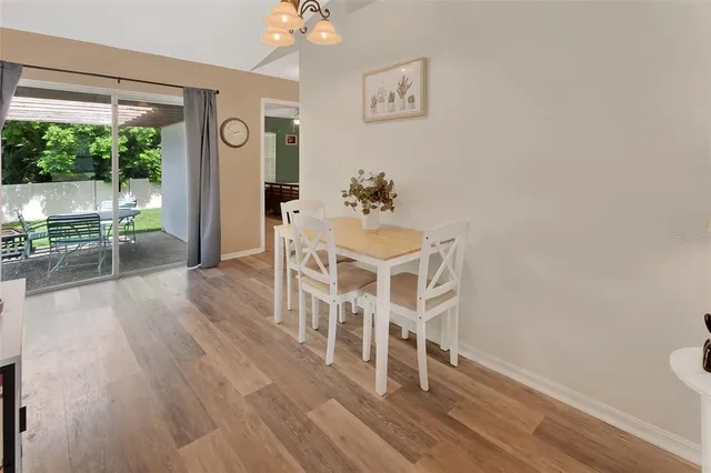 a dining room with wooden floor and a rug