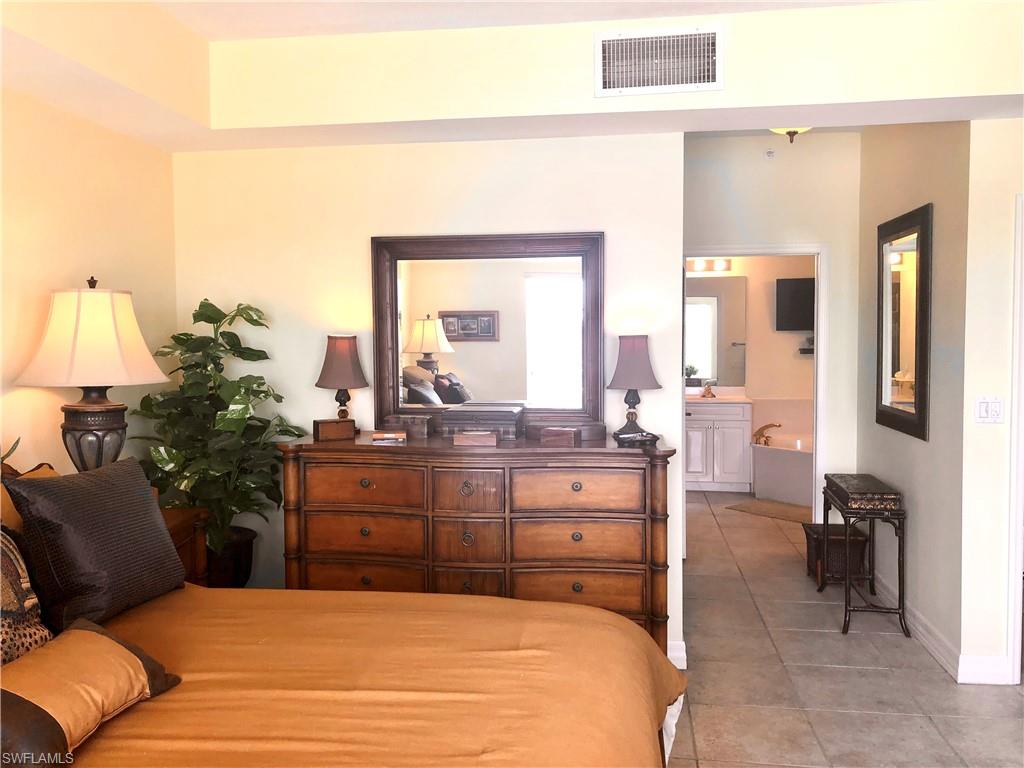 451 Bayfront Place, Unit 5311 Naples, FL 34102 - Photo 28 of 38 a bedroom with a bed and wooden floor