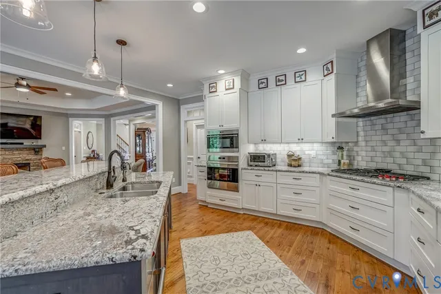 a large kitchen with stainless steel appliances granite countertop a stove and cabinets