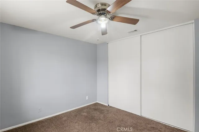 an empty room with a fan and a ceiling fan