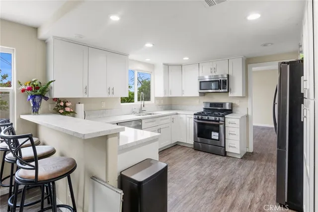 a kitchen with kitchen island white cabinets and stainless steel appliances