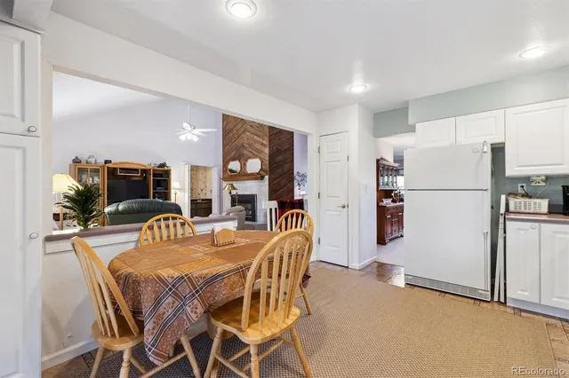 a dining room with furniture and a refrigerator
