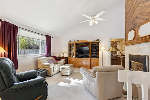 a living room with furniture a flat screen tv and a floor to ceiling window