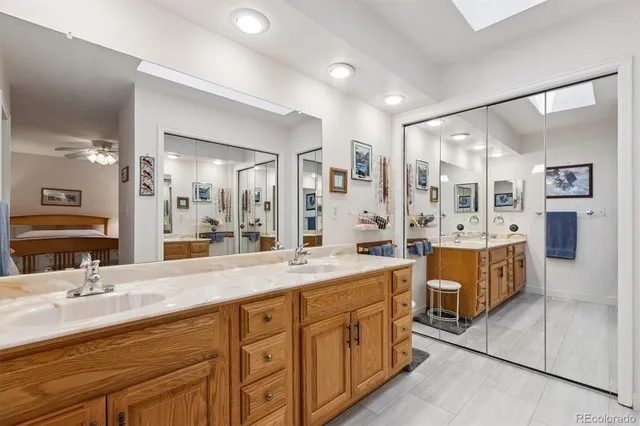 a spacious en suite bathroom with double vanity and a mirror