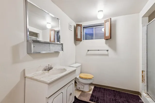 a bathroom with a sink mirror vanity and toilet