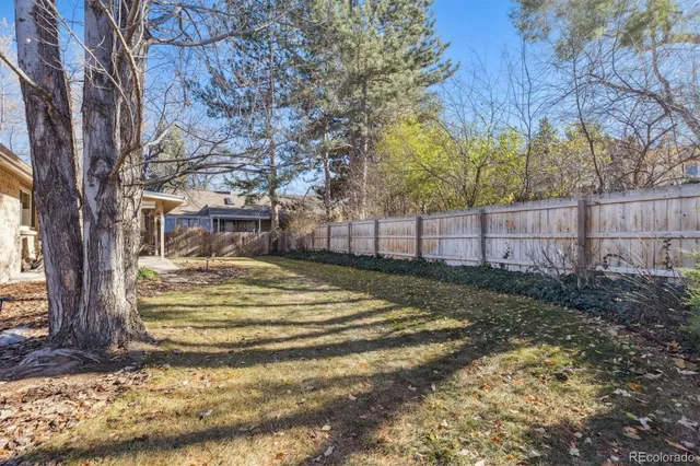 a view of backyard with wooden fence