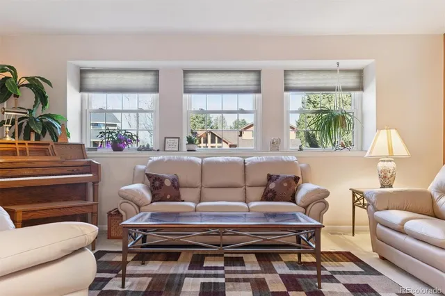 a living room with furniture a table and a large window