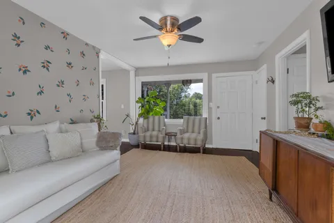 a living room with furniture and potted plants